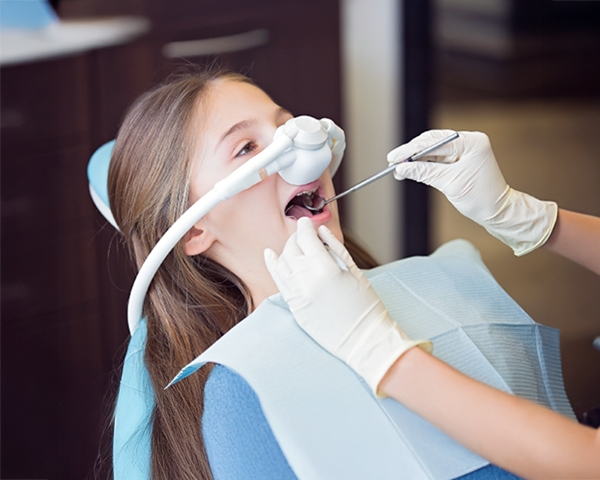 Paciente relaxado recebendo tratamento odontológico sob sedação consciente em clínica odontológica.