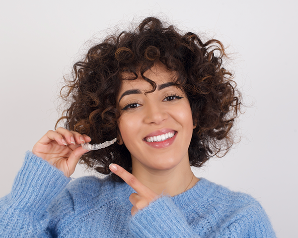 Invisalign versus Aparelho Convencional: Imagem comparativa de uma pessoa usando alinhador Invisalign transparente ao lado de outra usando aparelho convencional metálico.