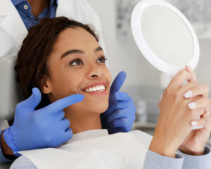 Paciente sorrindo após clareamento dental com dentes visivelmente mais brancos, representando estética e saúde bucal.