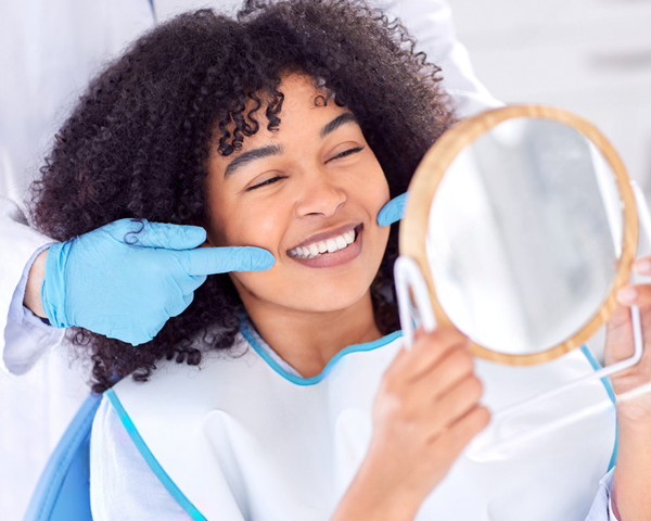 Sorriso harmônico de paciente após aplicação de lentes de contato dental, representando resultado estético natural e profissional.